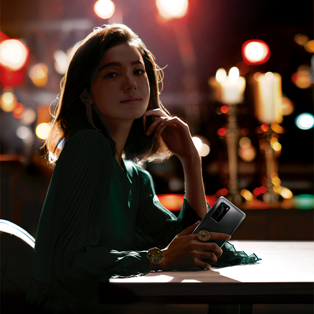 Girl at restaurant table with Huawei P40 phone in her hand